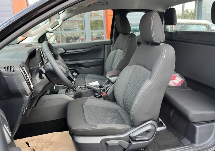 Vue intérieure côté conducteur du Ford Ranger 2025 noir shadow, montrant les sièges avant et la console centrale.
