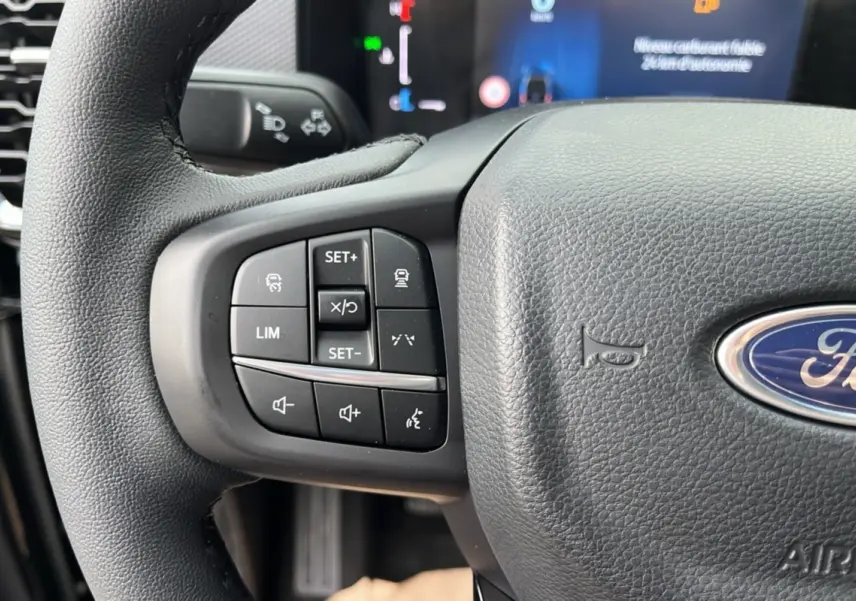 Gros plan sur la partie gauche du volant cuir multifonctions d'un Ford Ranger noir Shadow avec commandes intégrées.