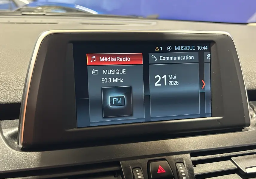 Écran central de la BMW Série 2 Active Tourer 216d affichant la radio FM et la date, vue de face intérieure.