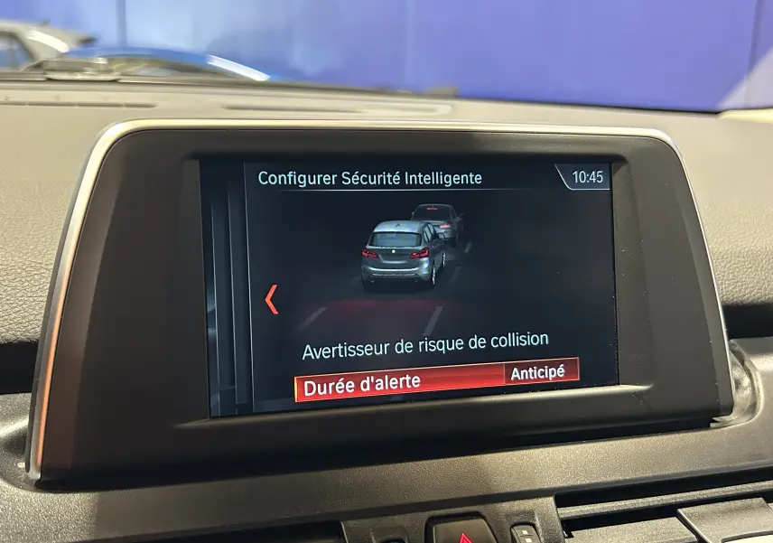 Écran central de la BMW Série 2 Active Tourer blanc montrant la configuration de l'alerte de risque de collision.