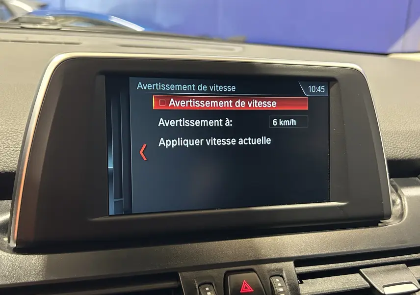 Écran central du tableau de bord d'une BMW Série 2 Active Tourer 216d blanc, affichant l'alerte de vitesse à 6 km/h.