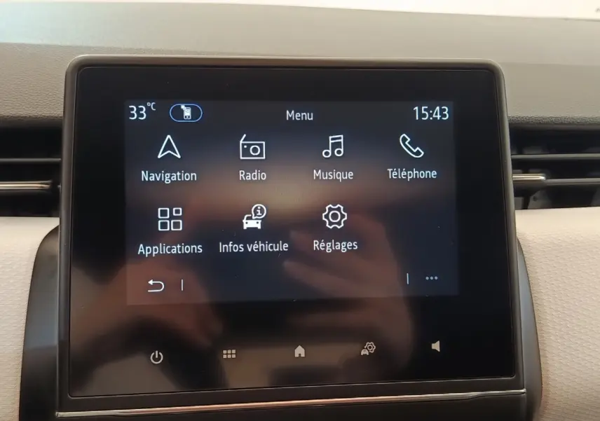 Écran tactile central de la Renault Clio 2023 affichant le menu principal avec navigation et radio.