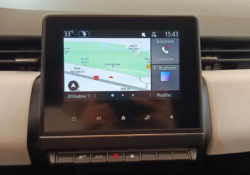 Écran tactile central affichant la navigation et options Bluetooth dans le tableau de bord d'une Renault Clio blanche.