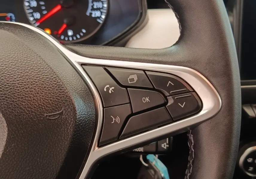 Gros plan sur le volant cuir noir de la Renault Clio 2023, avec commandes multifonctions visibles côté droit.