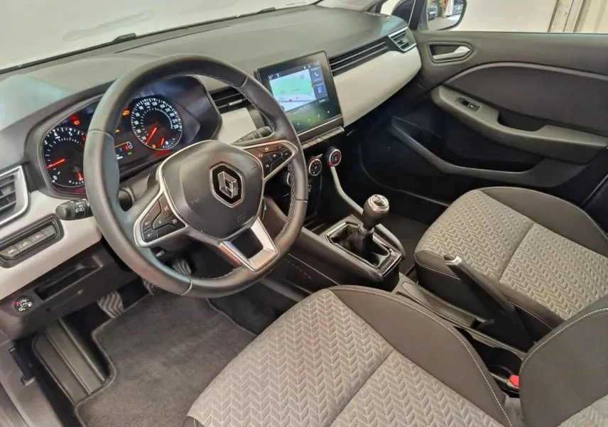 Vue intérieure avant droite de la Renault Clio 2023, volant cuir, écran tactile central et sièges tissu gris.