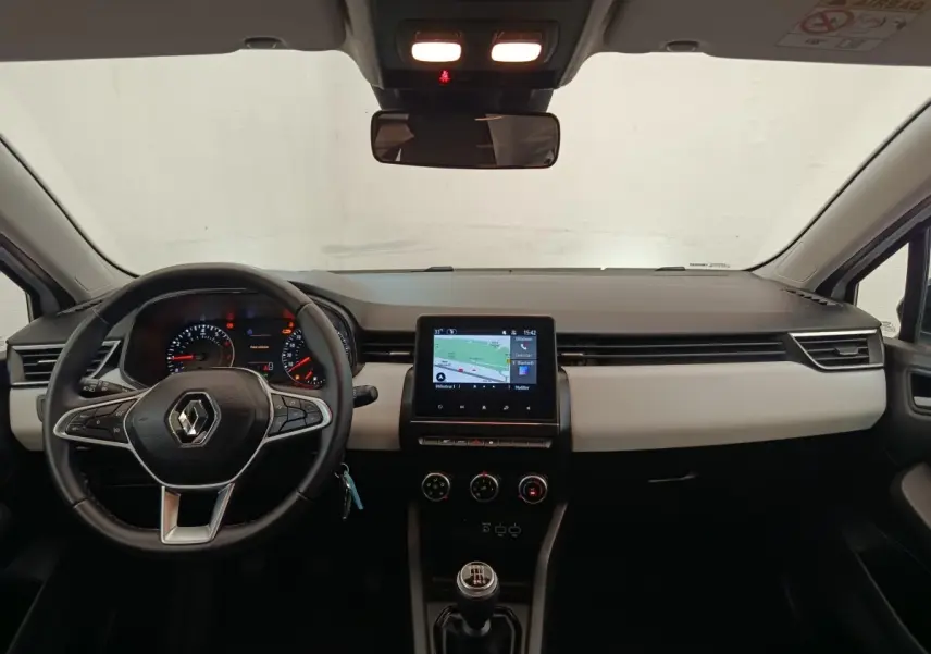 Vue intérieure frontale du tableau de bord de la Renault Clio blanc, avec écran tactile central et volant multifonctions.