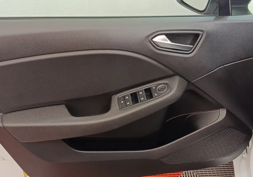 Vue intérieure du panneau de porte avant gauche de la Renault Clio blanche, avec commandes électriques des vitres et rétroviseurs.