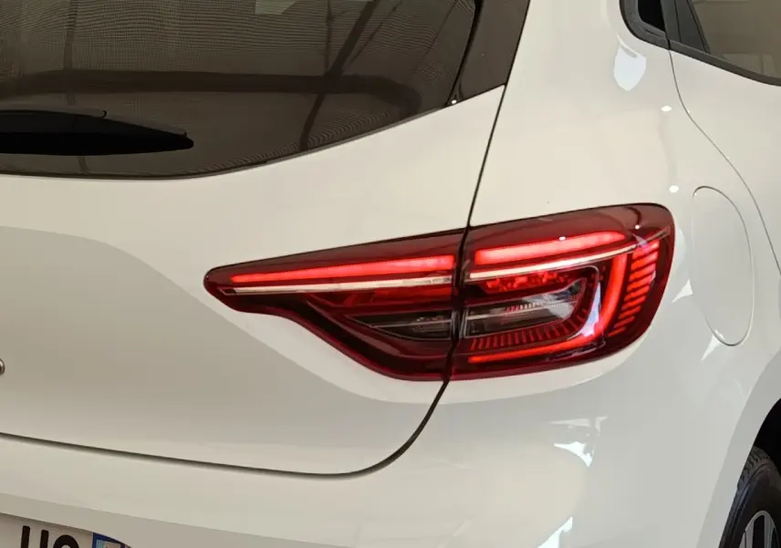 Gros plan sur le feu arrière droit rouge d’une Renault Clio blanche Evolution TCe 100 GPL, avec la trappe à carburant visible.