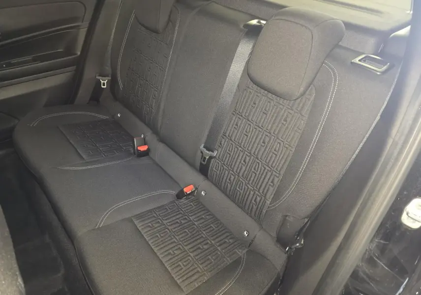 Vue intérieure de la banquette arrière noire du Fiat 600 Hybrid 2025 avec motifs FIAT embossés sur les dossiers.