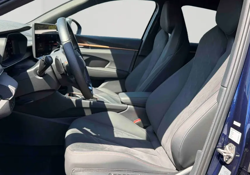 Vue intérieure côté conducteur du CUPRA Terramar bleu, sièges baquets suédine et cuir noir avec surpiqûres cuivrées.