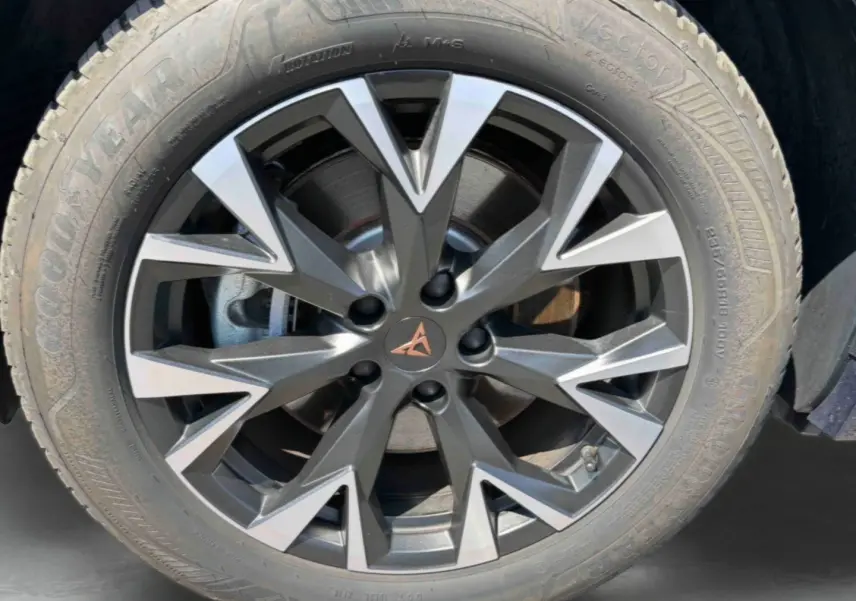 Gros plan sur la jante alliage gris anthracite et argentée avec logo CUPRA cuivré sur roue avant droite du CUPRA Terramar bleu.
