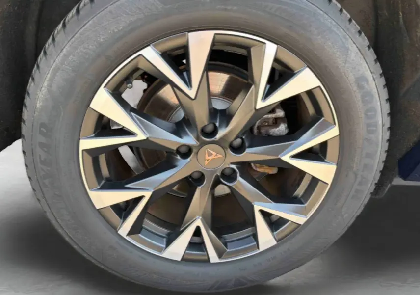 Gros plan sur la jante alliage 18 pouces au design géométrique bicolore avec logo CUPRA central, pneu Goodyear visible.
