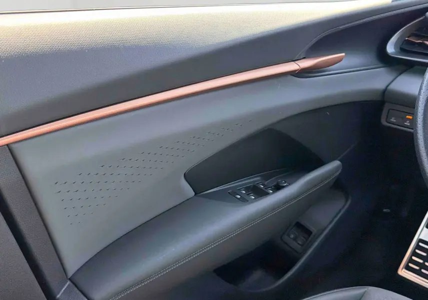 Vue intérieure côté conducteur de la porte CUPRA Terramar 2025 avec garniture noire et bande cuivrée élégante.