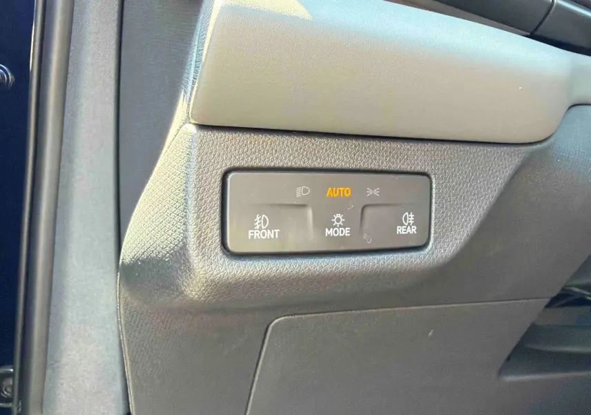 Détail du panneau de commande d’éclairage avec mode automatique sur la partie gauche du tableau de bord d’une CUPRA Terramar bleue.