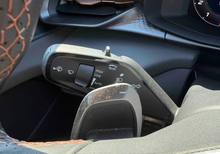 Gros plan sur la manette de commandes au volant cuir noir avec surpiqûres cuivrées du CUPRA Terramar 2025.