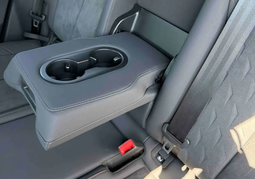 Détail de l'accoudoir central arrière avec porte-gobelets et sellerie suédine noire du CUPRA Terramar 2025.