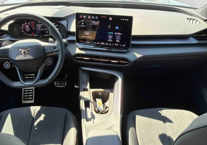 Vue intérieure du tableau de bord et volant noir de la CUPRA Terramar 2025 avec écran tactile central et sièges sport gris.