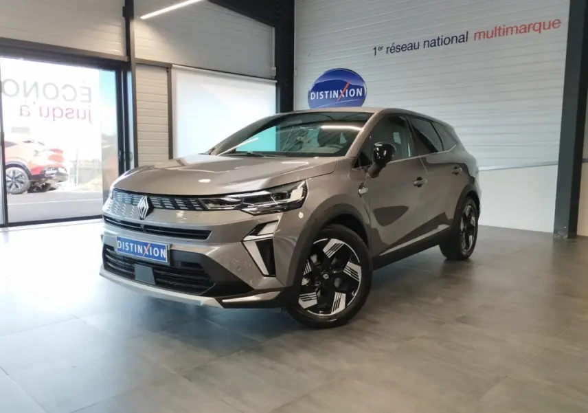 Renault Symbioz gris Cassiopée en 3/4 avant droit, avec jantes 18 pouces et détails noirs brillants en showroom.