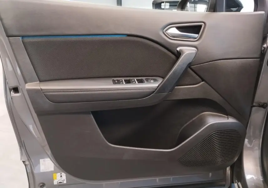 Porte intérieure côté gauche gris cassiopée de Renault Symbioz 2025 avec commandes de vitres et haut-parleur intégré.