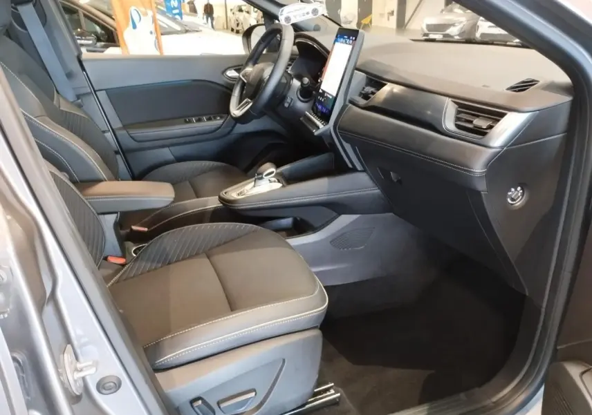 Intérieur avant droit de la Renault Symbioz gris Cassiope, avec sièges tissu et console centrale moderne.