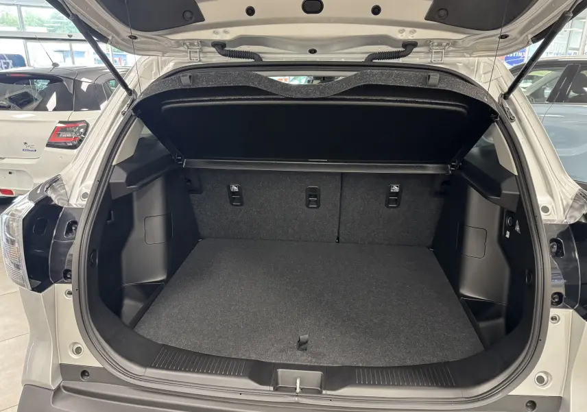 Coffre ouvert vu de l'arrière d'un Suzuki S-Cross gris 2025, montrant un espace de chargement propre et spacieux.
