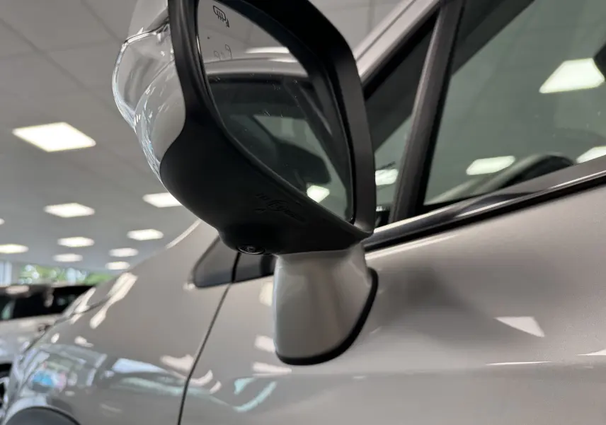 Gros plan sur le rétroviseur côté gauche du Suzuki S-Cross gris 2025, mettant en valeur sa finition hybride.