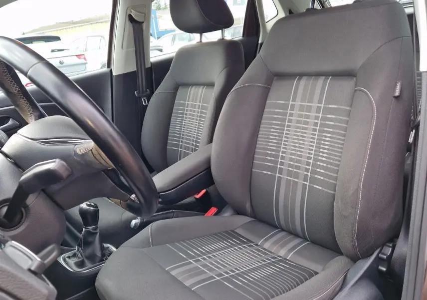 Vue intérieure côté conducteur de la Volkswagen Polo 1.4 TDI 2015, sièges tissu gris avec motifs géométriques.