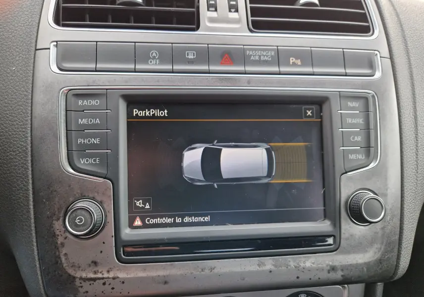 Vue rapprochée de l’écran central de la Volkswagen Polo 2015 affichant le système ParkPilot avec commandes autour.