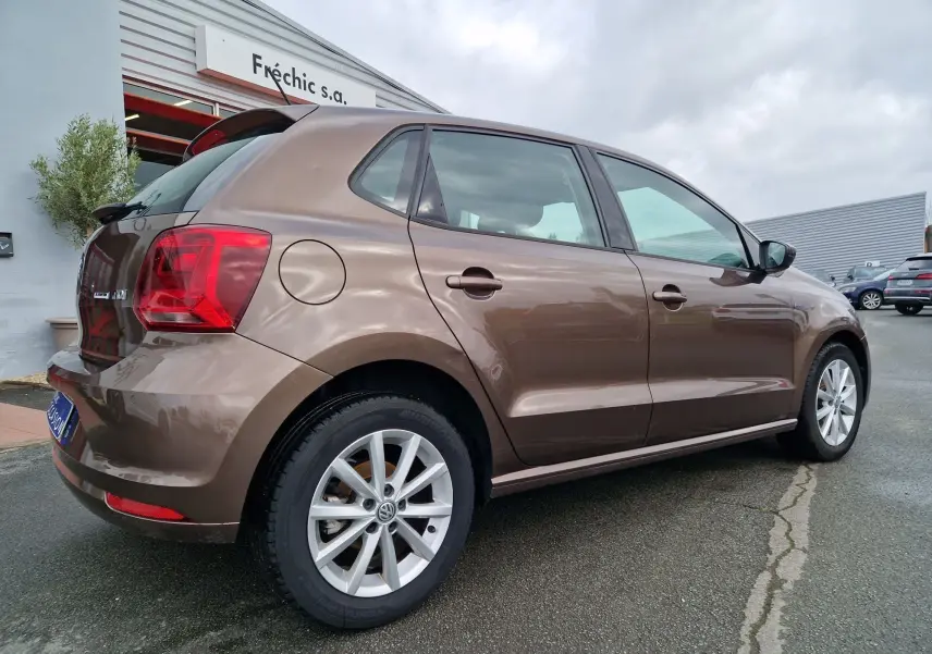 Volkswagen Polo 1.4 TDI brun vue 3/4 arrière droit, jantes alliage et feux arrière distinctifs visibles.