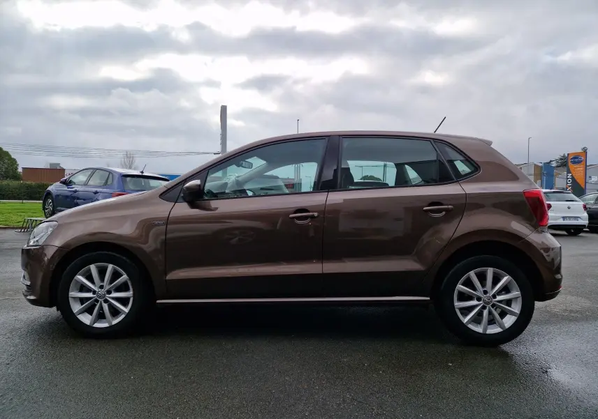 Vue de profil côté gauche d'une Volkswagen Polo 1.4 TDI 2015 brun avec jantes alliage et finition Lounge.