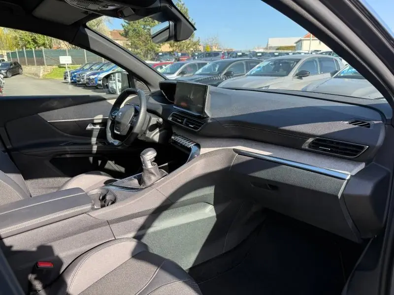 Vue intérieure côté conducteur du Peugeot 3008 2024 gris Platinium, avec tableau de bord moderne et boîte manuelle.
