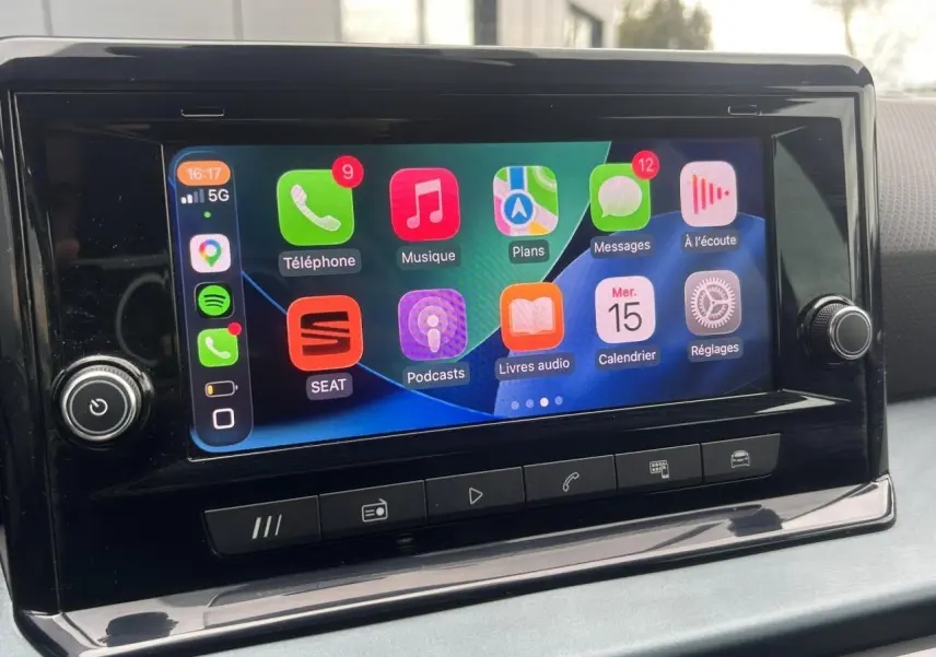 Écran tactile central du tableau de bord du SEAT Arona blanc, affichant l'interface Apple CarPlay colorée.