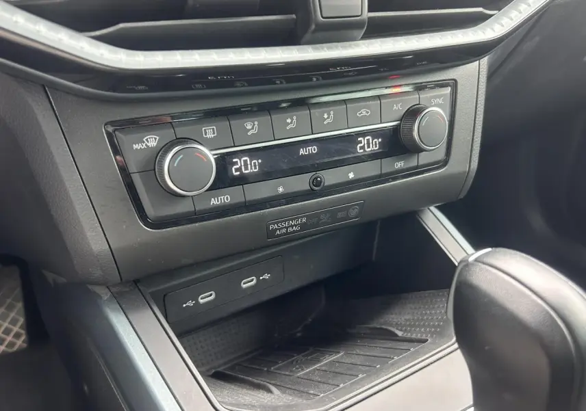 Gros plan sur la console centrale du SEAT Arona 2025, montrant la climatisation automatique bi-zone et les ports USB.
