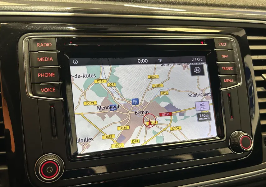 Vue rapprochée de l’écran GPS intégré au tableau de bord noir brillant d’une Volkswagen Coccinelle gris 2016.