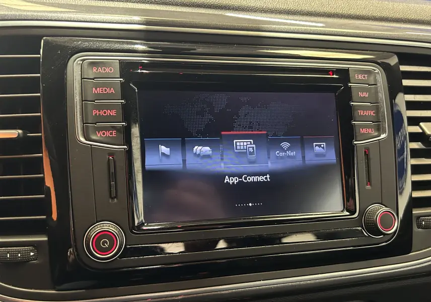 Écran tactile central du système GPS de la Volkswagen Coccinelle 2016, avec commandes autour et interface App-Connect.