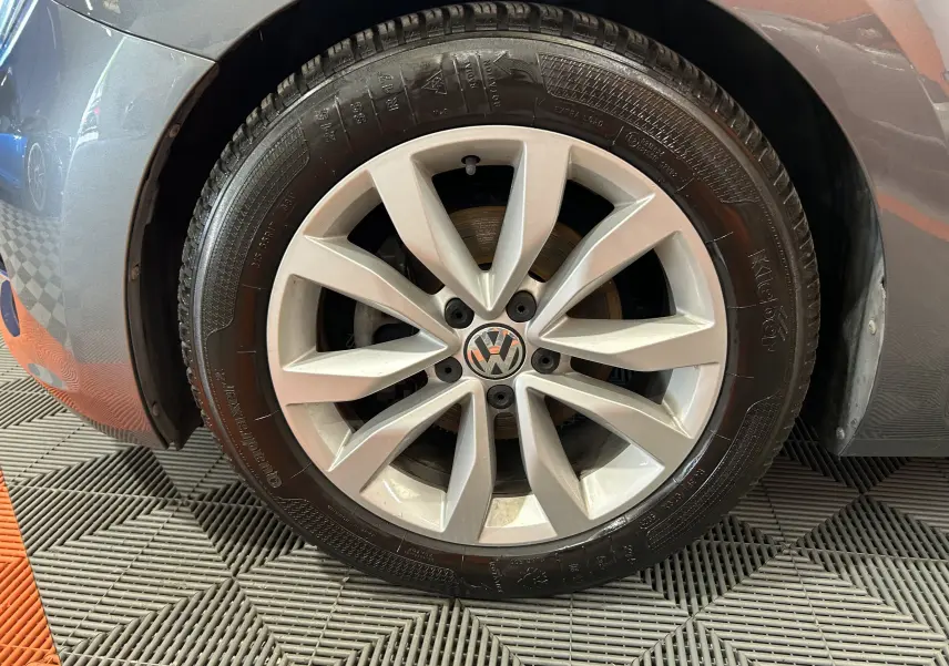 Gros plan sur la roue avant droite grise d'une Volkswagen Coccinelle 2016 avec jante alliage à 10 branches.