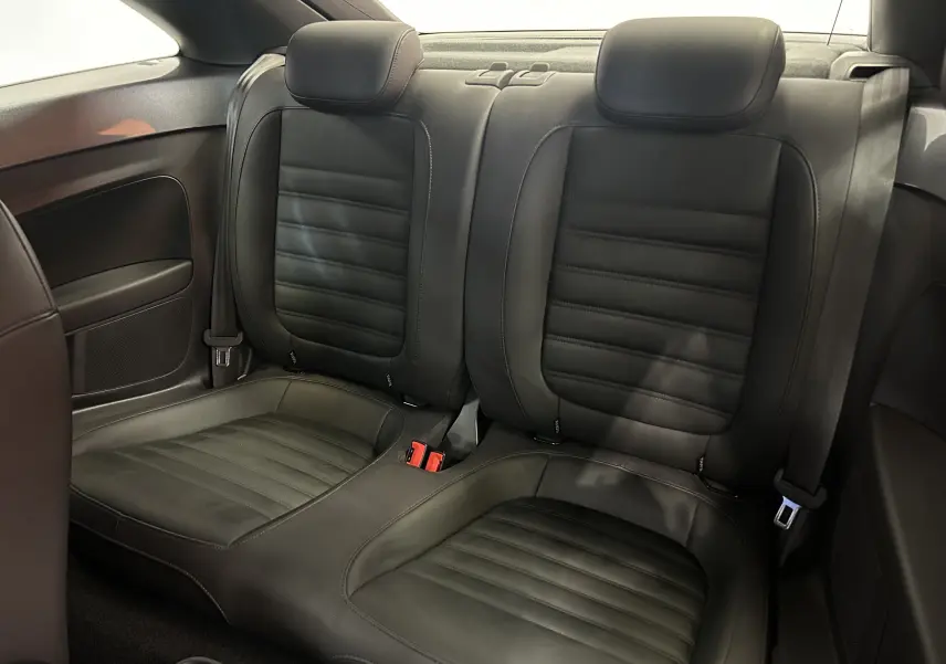 Vue intérieure des sièges arrière en cuir noir de la Volkswagen Coccinelle 2016, soulignant leur finition élégante.