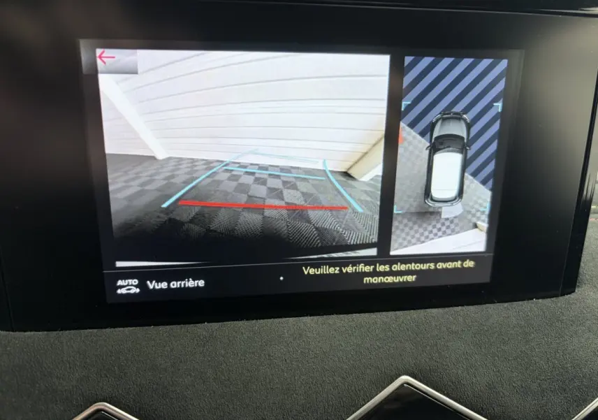 Écran tactile du DS3 Crossback blanc montrant la caméra de recul et la vue aérienne du véhicule en stationnement.