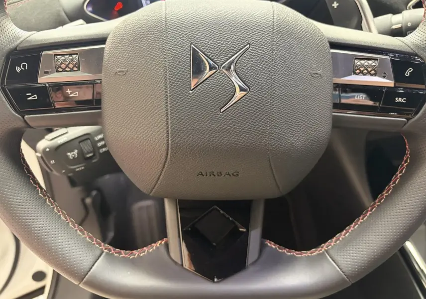 Gros plan sur le volant cuir noir du DS3 Crossback 2022 avec commandes multifonctions et logo DS central.