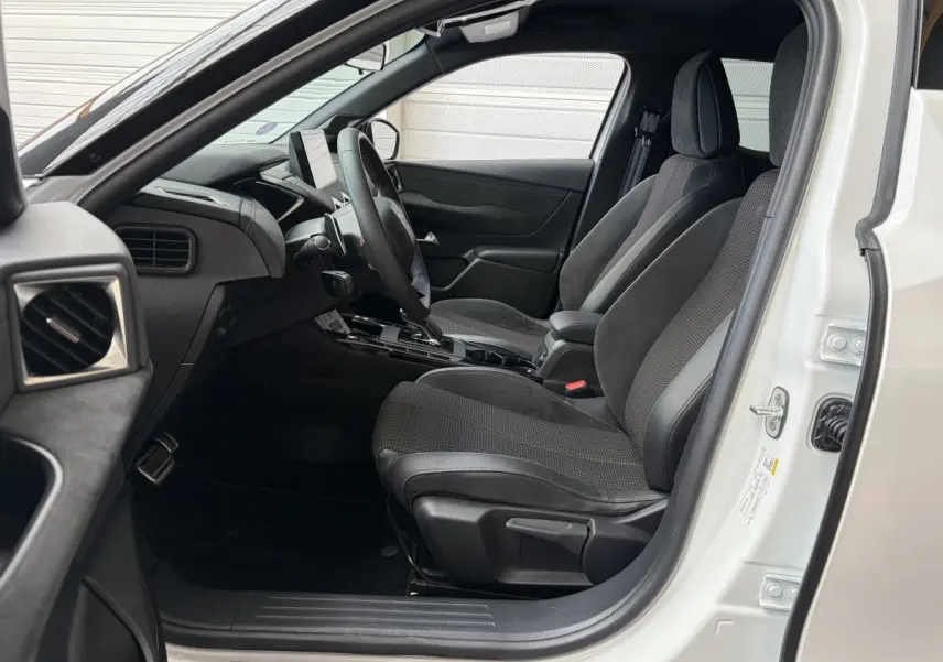 Vue intérieure côté conducteur d’un DS3 Crossback blanc 2022, sièges noirs et tableau de bord moderne avec écran tactile.