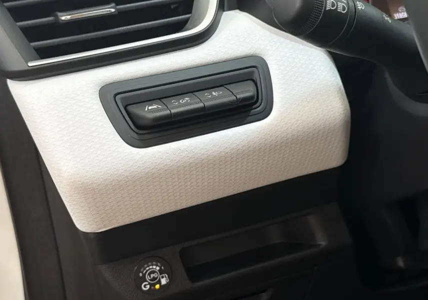 Détail du tableau de bord blanc de la Renault Clio Evolution TCe 100 GPL 2023 avec commandes d’assistance et indicateur GPL.