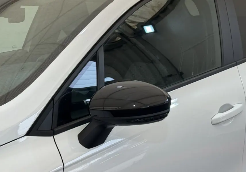 Gros plan sur le rétroviseur noir côté conducteur d’une Renault Clio blanche Evolution TCe 100 GPL 2023.