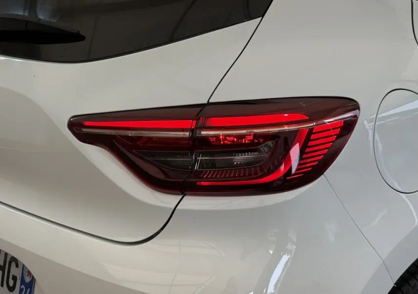 Gros plan sur le feu arrière droit rouge d’une Renault Clio blanche Evolution TCe 100 GPL de 2023.