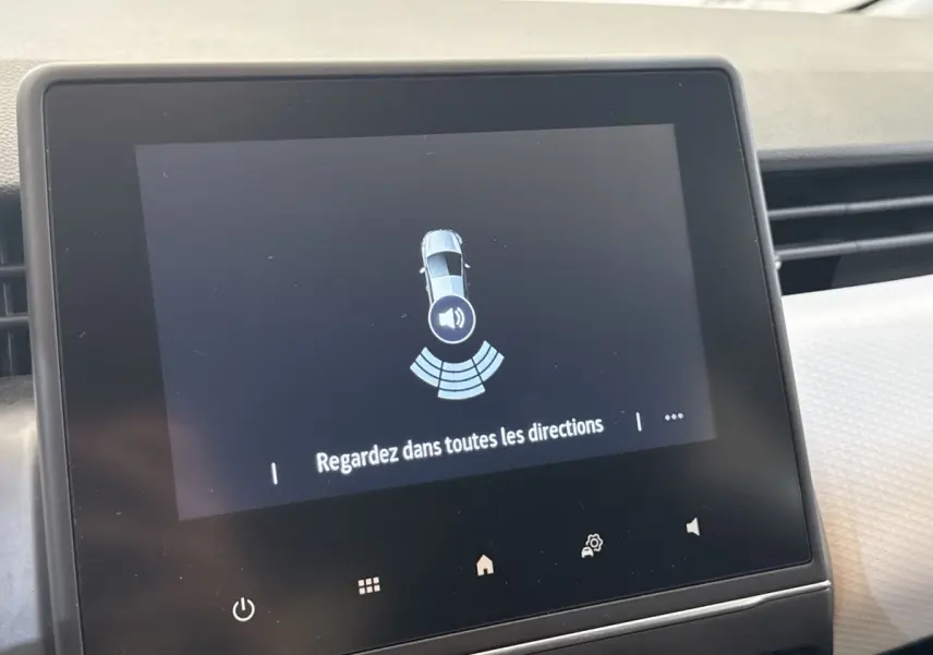 Écran tactile central de la Renault Clio blanche 2023 affichant l'alerte de surveillance tous angles.