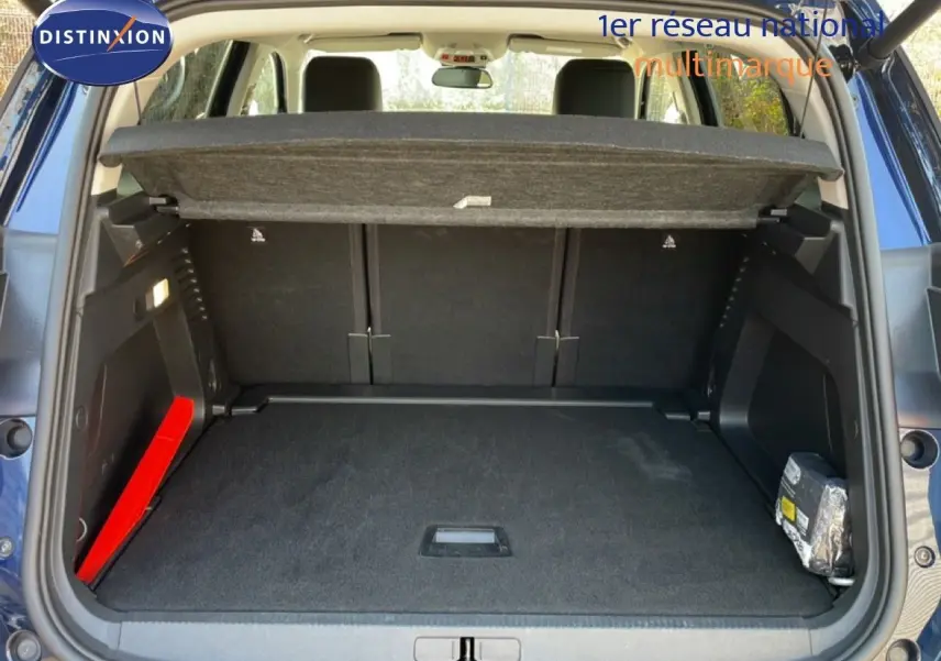 Vue arrière du coffre ouvert d'un Citroën C5 Aircross bleu Eclipse Metal, montrant un espace de rangement propre et bien agencé.