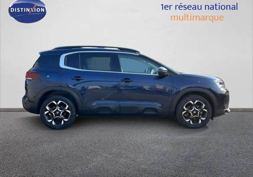 Profil droit d'un Citroën C5 Aircross 2025 bleu Eclipse Métal avec jantes alliage et barres de toit noires.
