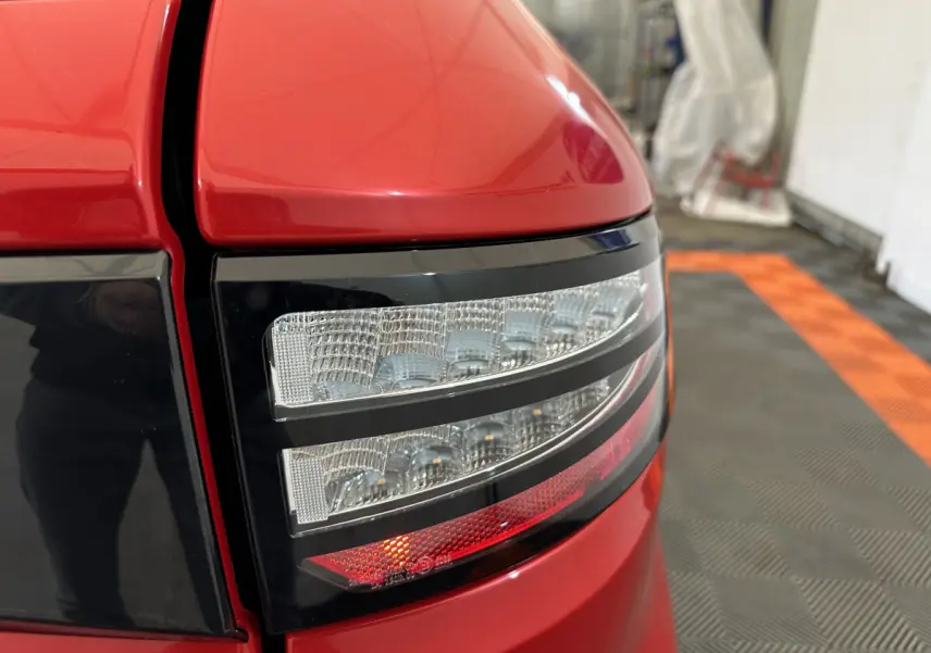 Gros plan sur le feu arrière droit rouge de l'AIXAM AMBITION 0.5 CITY COUPE GTI E5+ 2026 avec détails lumineux nets.