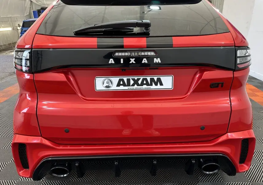 Vue arrière d'une Aixam Ambition rouge 2026 avec bande noire, logo AIXAM et double sortie d'échappement GTI.