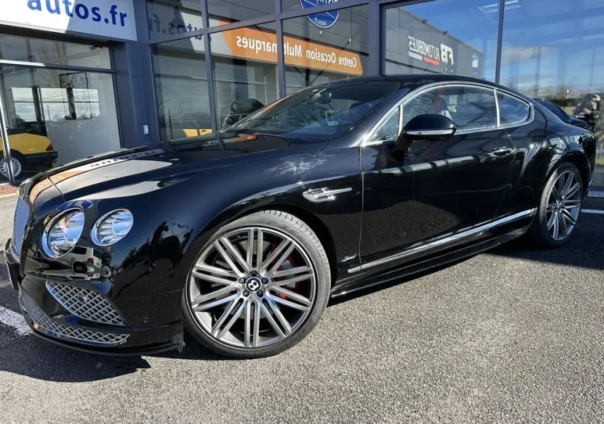 Bentley Continental GT Speed noire vue de profil avant droit, jantes alliage distinctives et calandre chromée.