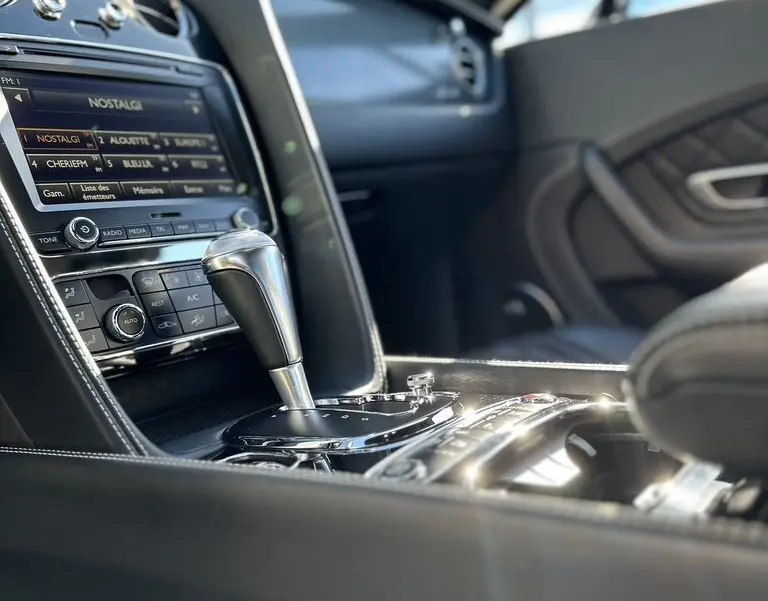 Intérieur noir de Bentley Continental GT Speed 2015, vue rapprochée sur la console centrale et levier de vitesse automatique.